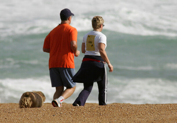 Older couple jogging along the beach