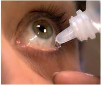 An eye with lower lid pulled down and eye drops being dropped in