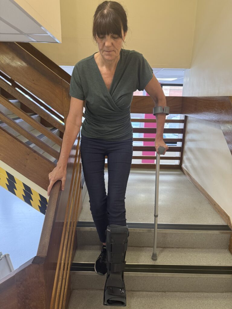 Going Downstairs holding crutch