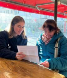 Maria reading her appointment letter with a carer. 