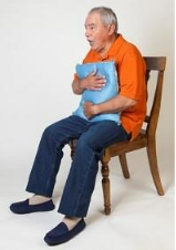 Man holding a pillow against his chest