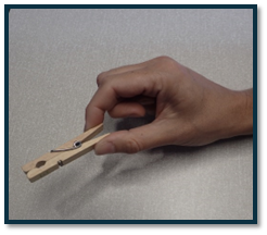 A hand holding a clothespin