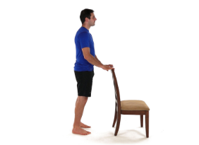 A person holding the back of a chair. © Wibbi