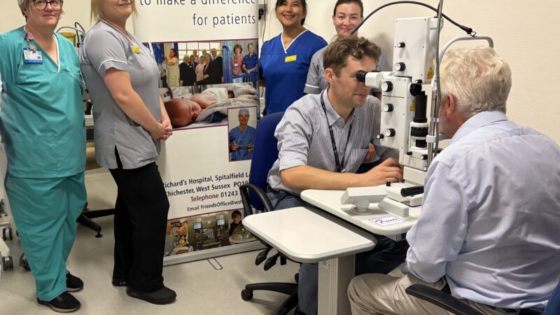 Ophthalmologist using the new machine at St Richard's Hospital. Seen in the background are members of the ophthalmology nursing team.