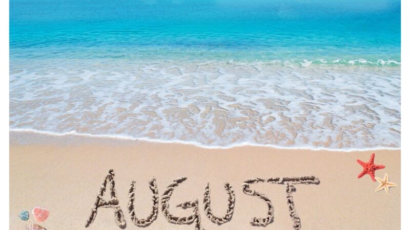Picture of a beach with blue sea and the word August written i the sand
