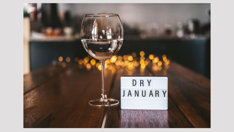 Empty glass of wine on a table with a notice saying 'Dry January'