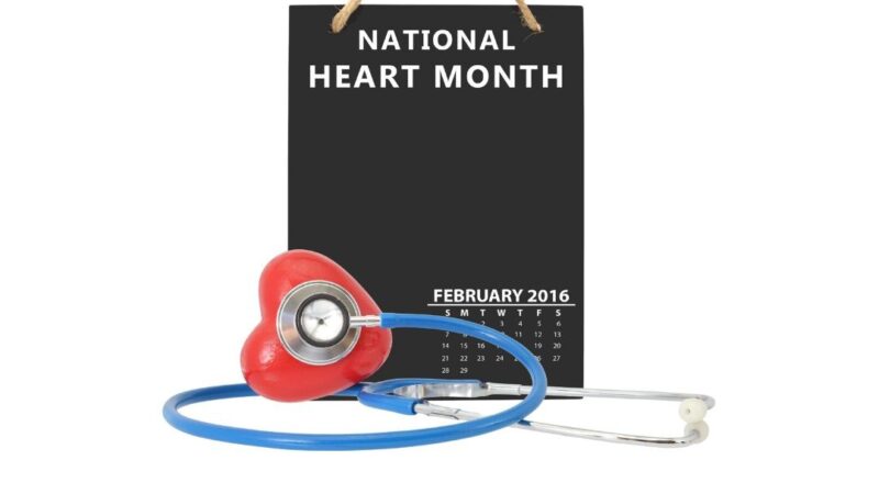A blackboard with 'National Heart Month' chalked on it. With a stethoscope and red heart.
