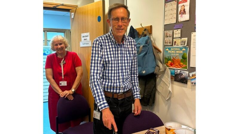 Roland, one of our senior library assistants cutting a cake