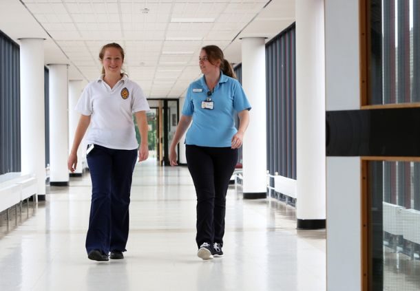 Two staff walking a corridor in a hospital