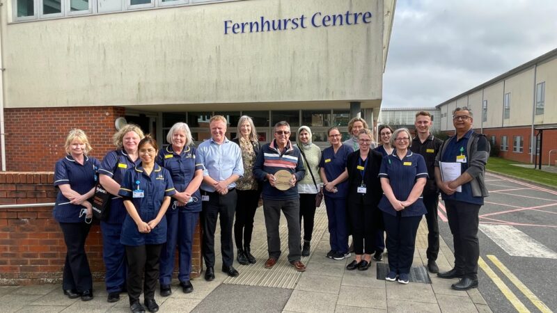 Fernhurst centre staff with former patient receiving award.
