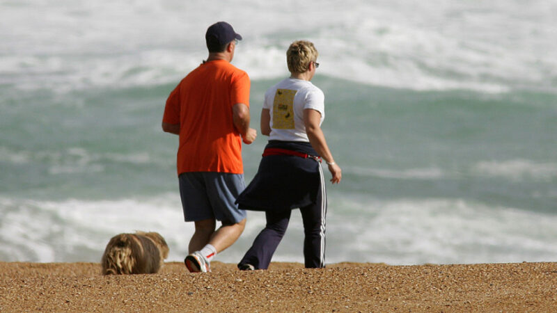 Older couple jogging along the beach